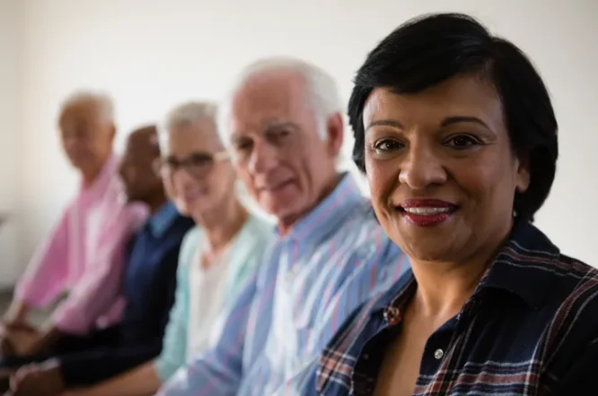 Diverse group of older adults, including a smiling woman in the foreground, representing community engagement in estate planning workshops by Legacy Peace.