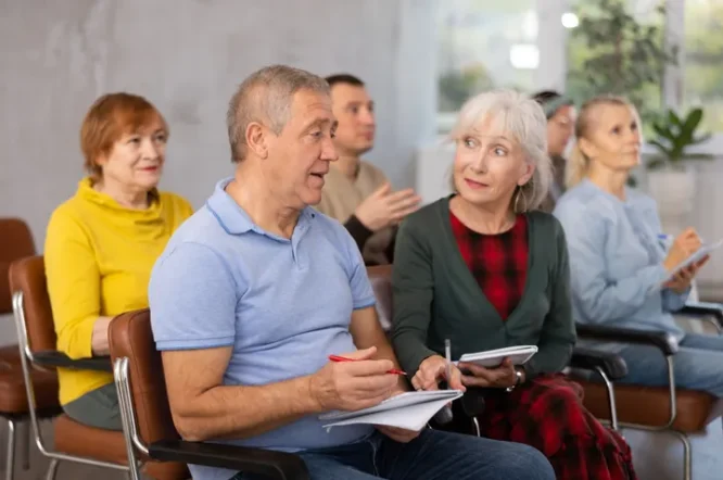 Group of adults attending an estate planning workshop, taking notes and engaging in discussion, highlighting Legacy Peace's educational focus.